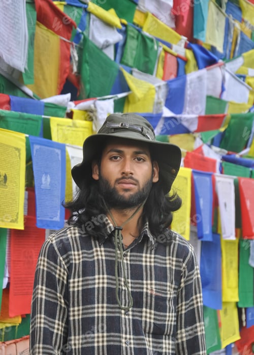 Preview: A bearded and long haired male tourist looking at camera while standing
