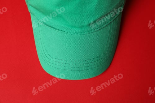 Preview: Green baseball hat on red background, top view. Mockup for design