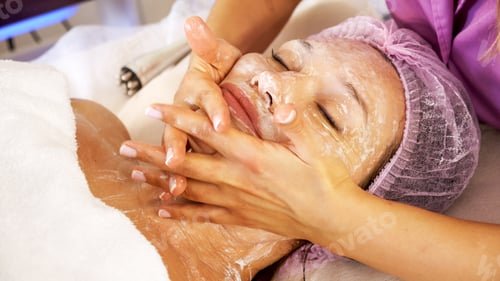 Preview: Cosmetologist applies a moisturizing mask on female face.