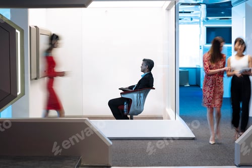 Preview: Businessman sitting chair on a busy office floor, working