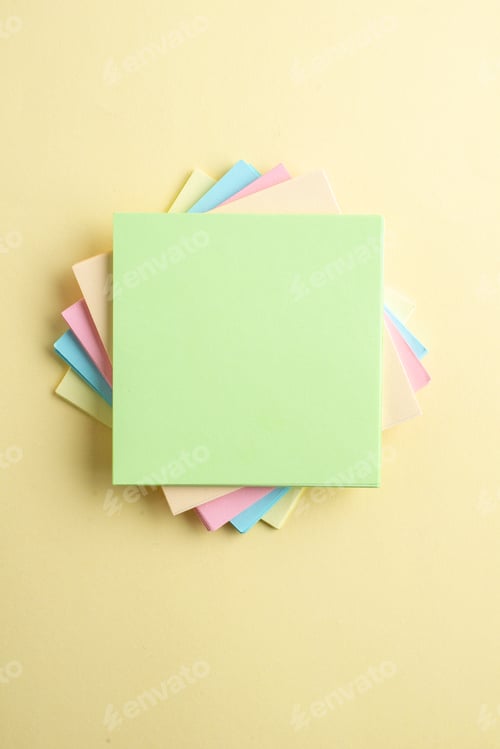 Preview: Overhead view of stacked sticky note cubes on shaded yellow background with free space