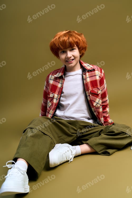 Preview: Little boy showcases unique fashion style with a cheerful expression in a cozy setting