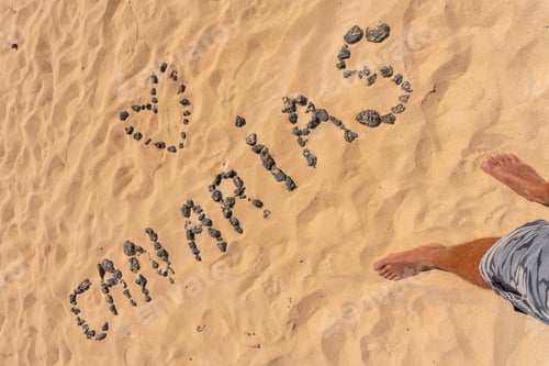 Preview: Canary name with black stones on the beach of the dunes of the Corralejo