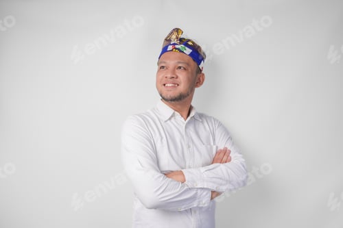 Preview: Portrait of a Balinese wearing traditional headdress called udeng posing with a crossed arms.