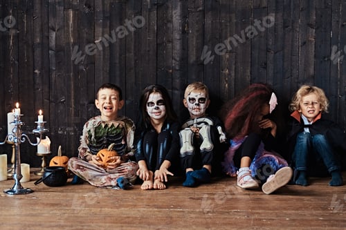 Preview: Halloween party with group children who sitting together on a wooden floor in an old house