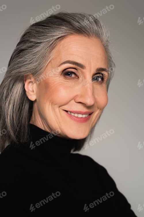 Preview: Portrait of smiling mature woman isolated on grey