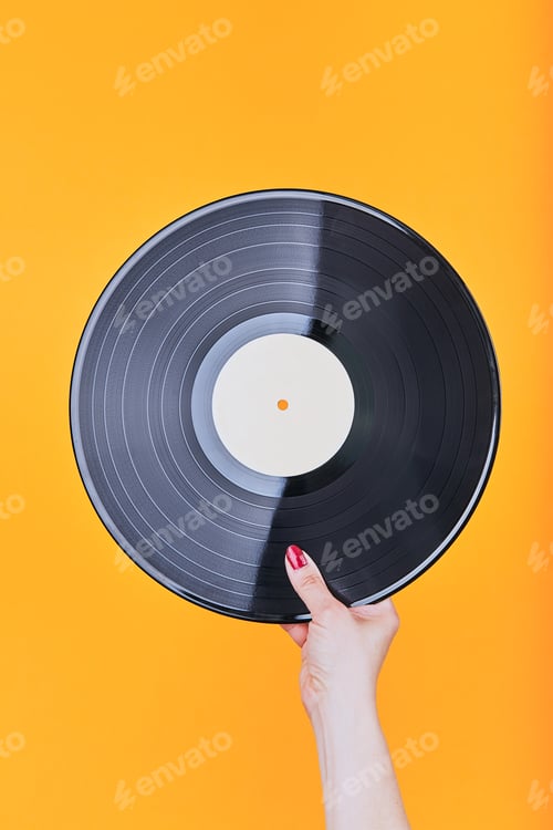 Preview: Female hand holding black vinyl record over a plain orange background. Minimal style