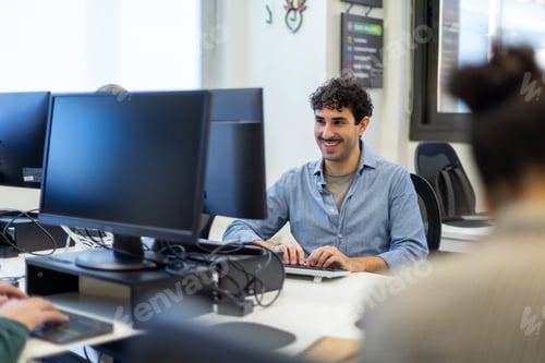 Preview: Developer working on computer smiling in office