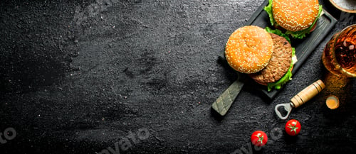 Preview: Burgers with beer in a glass and tomatoes.