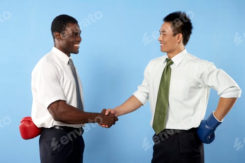 Preview: Businessmen Shaking Hands With Boxing Gloves Behind Backs