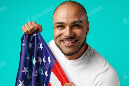 Preview: Portrait of young dark-skinned man proudly holding USA flag