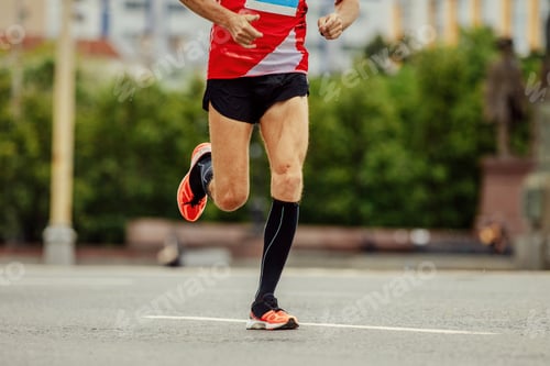 Preview: young runner in black compression socks running street in city marathon