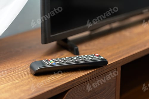 Preview: Remote control rests on wooden table beside a television set in cozy living room