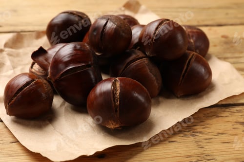 Preview: Fresh edible sweet chestnuts on wooden table, closeup