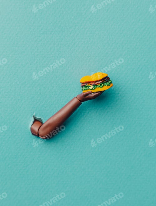 Preview: Miniature black human hand holds burger