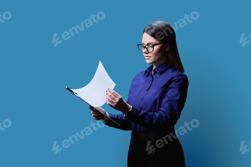 Preview: Young business woman holding clipboard, on blue background