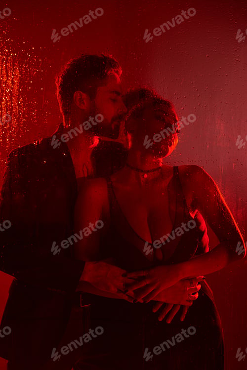 Preview: A passionate couple embraced in a red lit atmosphere, enjoying a moment of intimacy and love