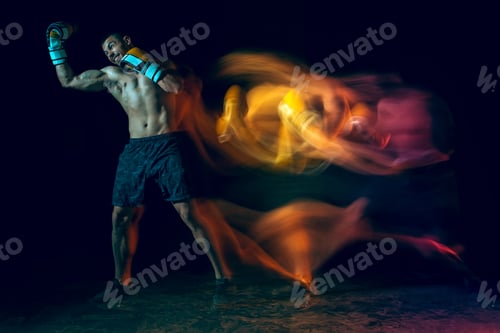 Preview: Male boxer boxing in a dark studio