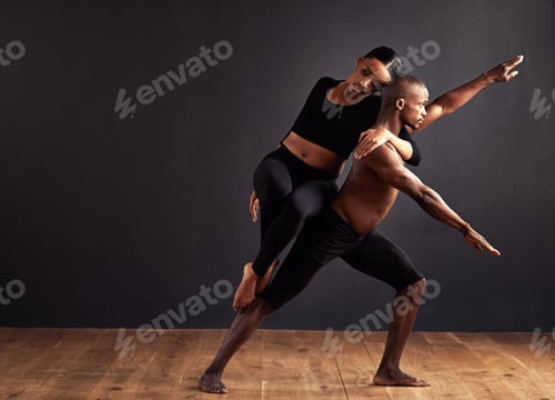 Preview: A female and male contemporary dancer performing a dramatic pose in front of a dark background