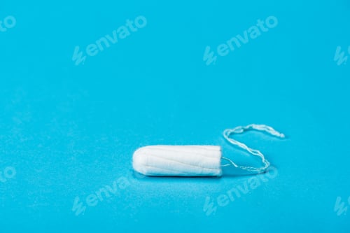 Preview: one menstrual tampon isolated on blue