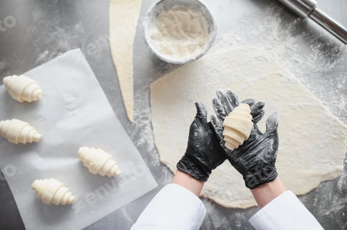 Preview: Baker showing freshly made croissant in bakery