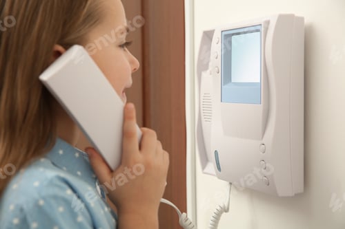 Preview: Cute little girl answering intercom call indoors, closeup