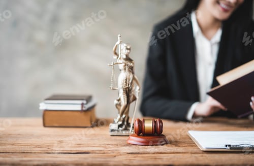 Preview: Asian female lawyer or legal advisor working with scales of justice Sitting at her desk holding a bo