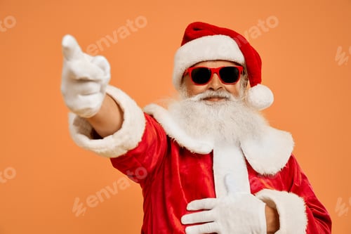 Preview: Senior bearded man in Santa costume pointing on by finger