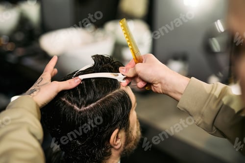 Preview: Caucasian Young Adult Man Getting Hair Styled by Barber in Modern Barbershop