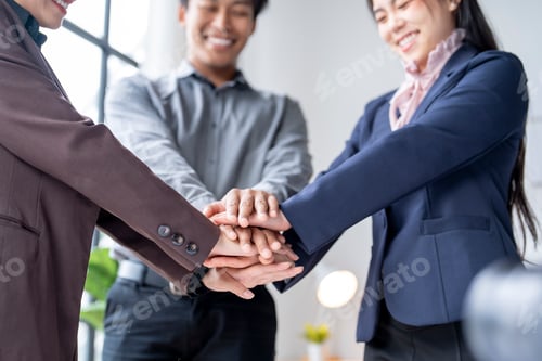 Preview: Business people stacking hands showing teamwork and unity