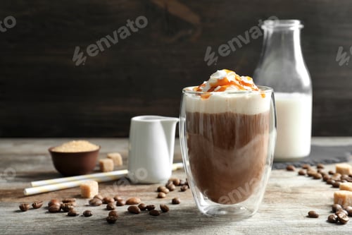 Preview: Glass of coffee with caramel topping on wooden table