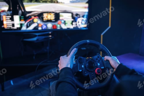 Preview: Using steering wheel. Young guy is playing racing game by using driving simulator