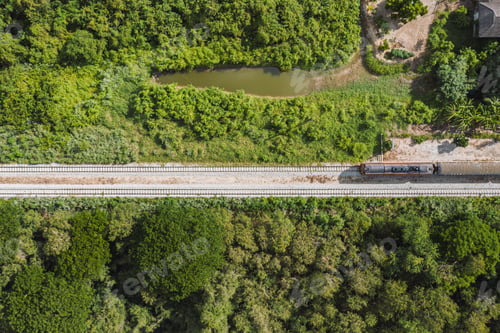 Preview: Vintage train driving on railway track in tropical forest at countryside