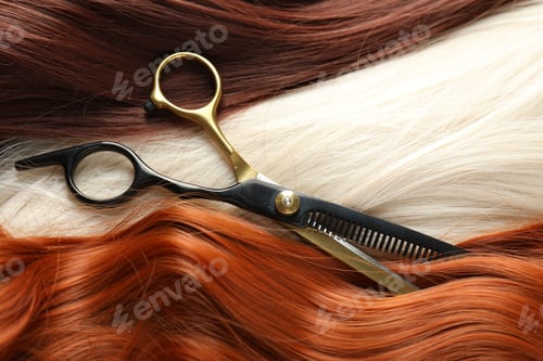 Preview: Strands of different beautiful hair and hairdresser's scissors, above view