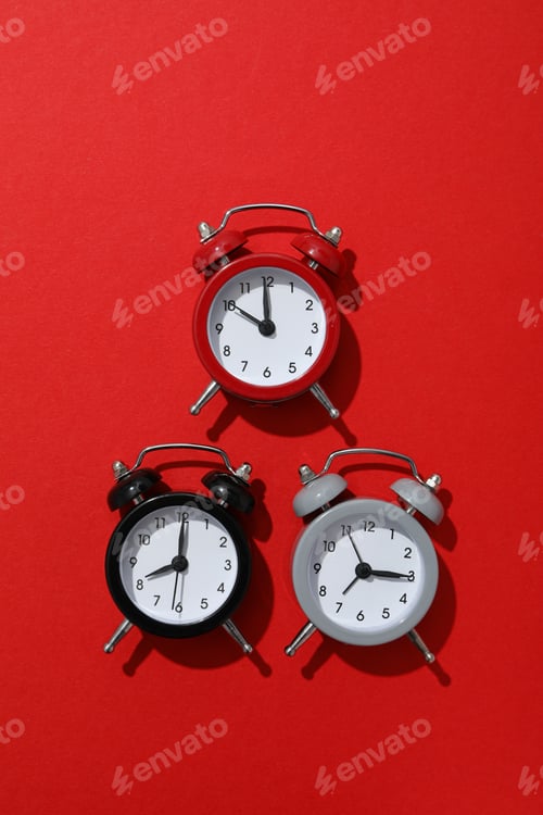 Preview: Classic multi-colored alarm clocks with on a red background