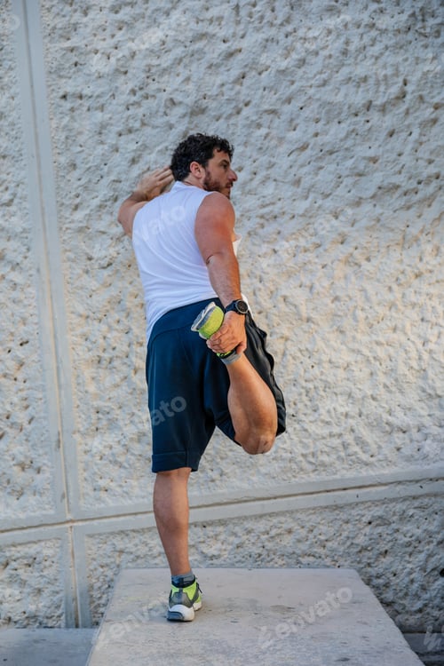 Preview: Adult sportsman exercising near wall