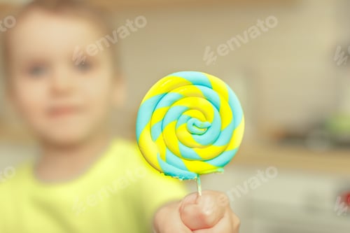 Preview: defocused boy take lollipop