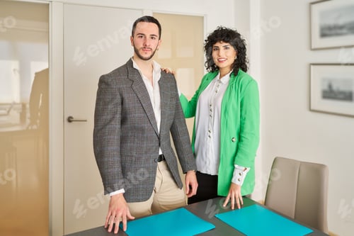 Preview: A businessman and a businesswoman are standing in front of a table.