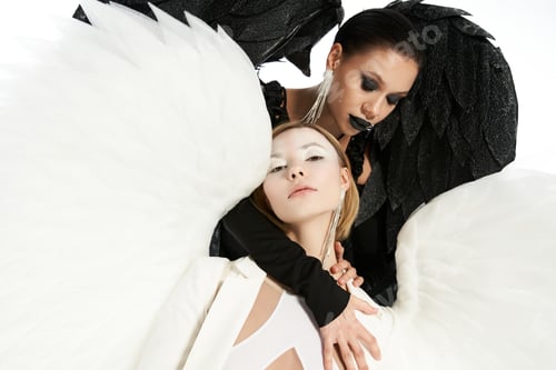 Preview: black demon embracing and tempting light holy angel on white backdrop, spiritual warfare concept
