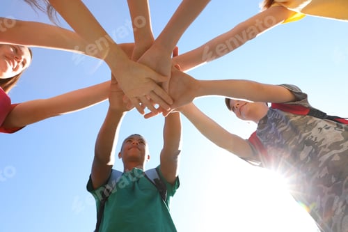 Preview: Group of children putting hands together outdoors. Summer camp
