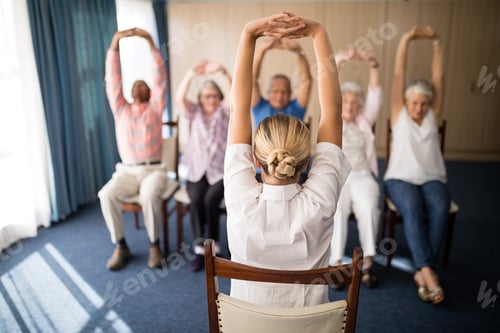 Preview: Rear view of female doctor exercising with senior people
