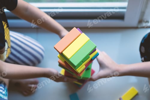 Preview: Kids’ hands while they play wooden brick tower