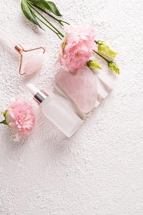 Preview: White matte bottle with natural remedy, serum, massage oil,massager and gua sha on white podium