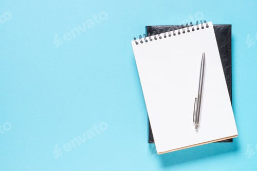 Preview: Notebook and pen on blue background