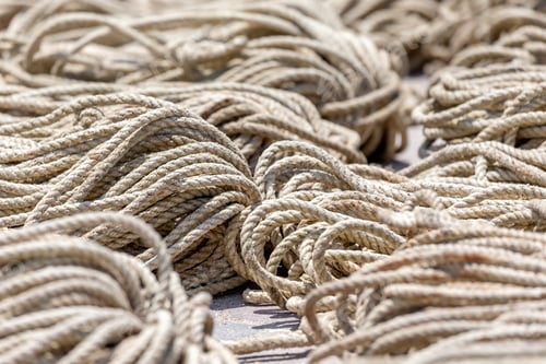 Preview: Old heavy duty rope laying outside on the asphalt, closeup