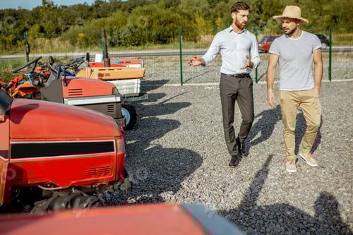 Preview: Men Discussing Farm Equipment on a Gravel Lot