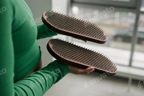 Preview: Unrecognizable Young Woman Holding Nail Board in Yoga Studio