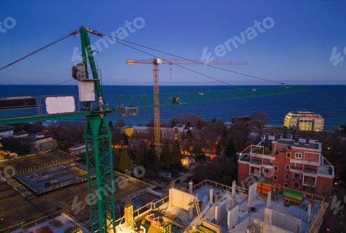 Preview: Busy Construction Site and Construction Equipment at night. Aerial view