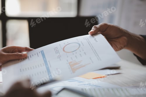 Preview: Two businessmen looking together at business documents.