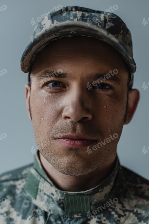 Preview: portrait of sad soldier in military uniform crying during memorial day isolated on grey